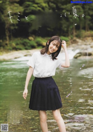 A young woman in a school uniform sitting on the ground.