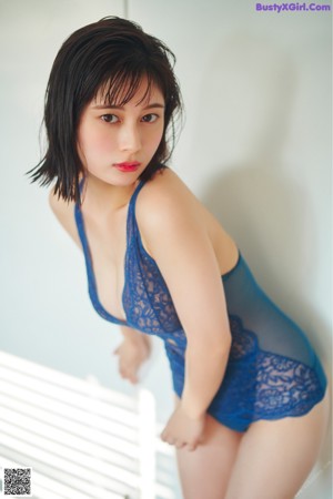 A woman in a blue panties laying on a bed.