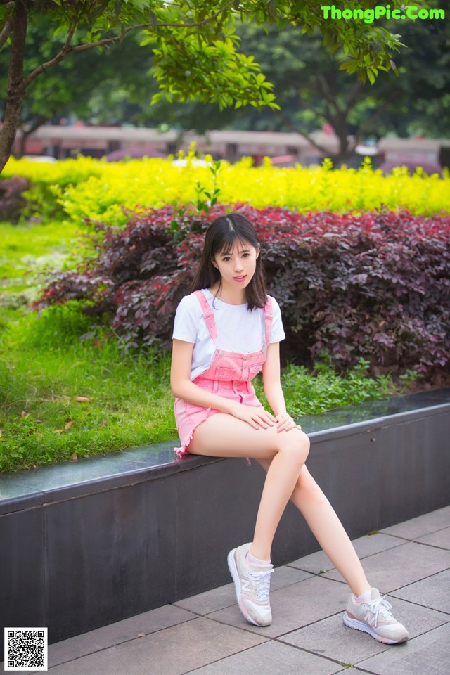 A woman sitting on a bench in a park.