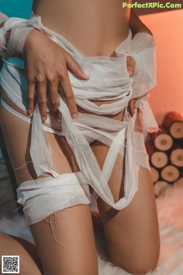 a woman in a white lingerie sitting on a bed