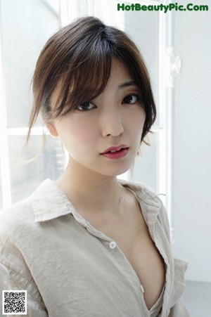 A woman in a white tank top posing for a picture.