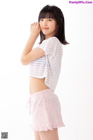 A woman in a white shirt and pink shorts posing for a picture.