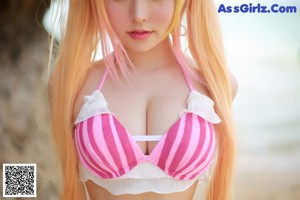 A woman in a pink and white bikini posing for a picture.