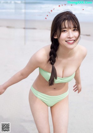 A woman in a red bikini laying on the beach.