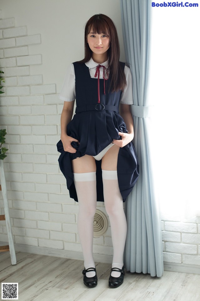 A woman in a school uniform posing for a picture.