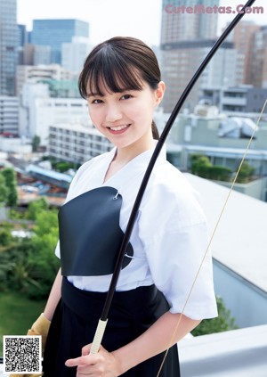 A woman in a yellow dress holding a black umbrella.