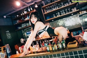 A woman in lingerie sitting at a bar.