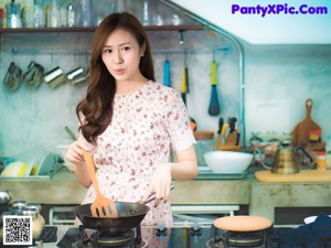 A woman with long brown hair wearing a floral shirt.