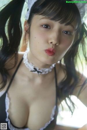 A woman in a maid outfit laying on a table.