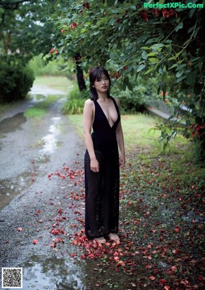 A naked asian woman sitting on the edge of a bathtub.