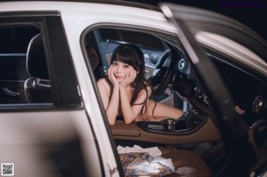 A woman sitting in the back seat of a car.