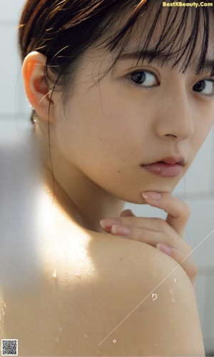 A woman with wet hair is posing for a magazine cover.