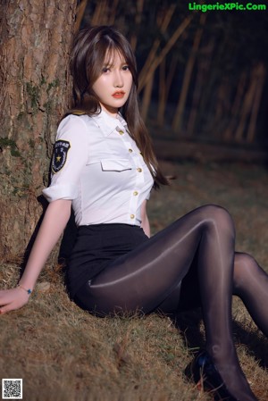 A woman in black pantyhose and high heels posing in the woods.
