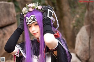 A woman with purple hair holding a bow and arrow.