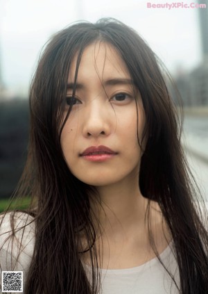 A woman in a white dress sitting on a bench.