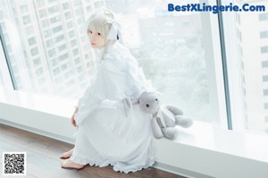 A woman sitting on a couch holding a stuffed animal.