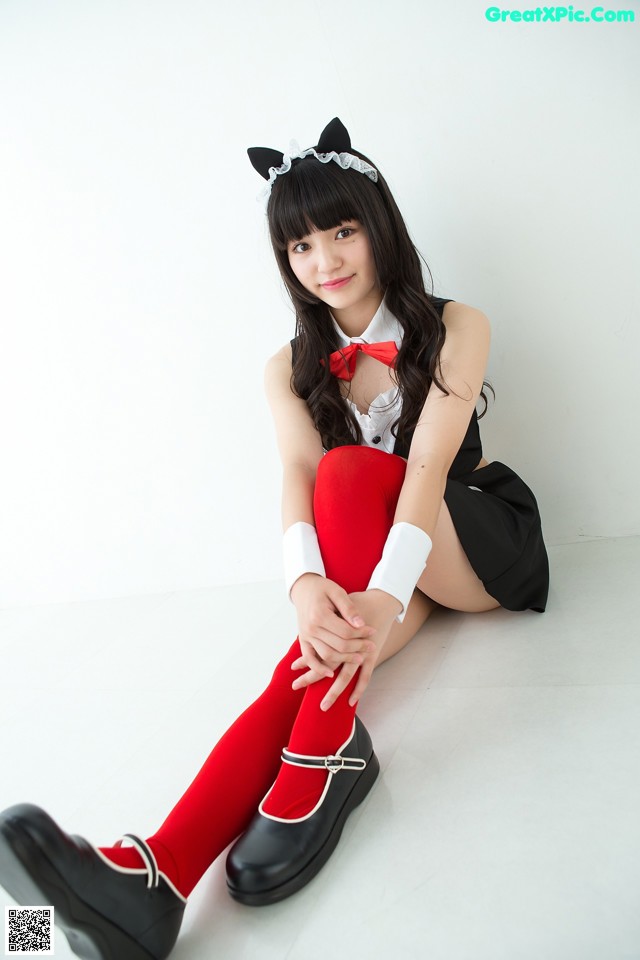 A woman in a cat costume sitting on the floor.