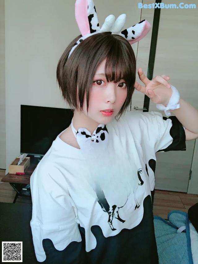 A woman wearing a white shirt with a cow on it.