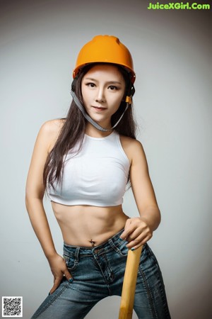 A woman in a hard hat is posing for the camera.