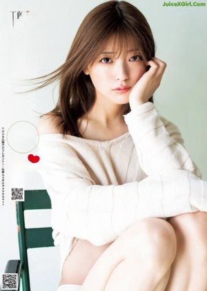 A woman in a white sweater posing for a picture.