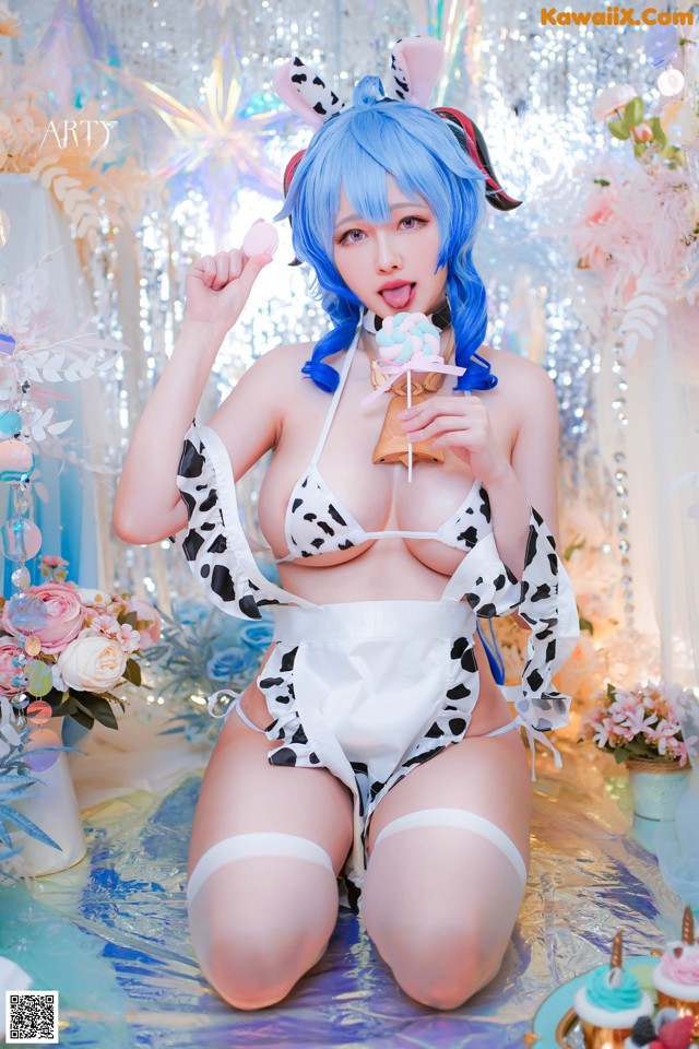 A woman in a cow print bikini holding a lollipop.