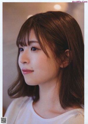 A magazine page with a picture of a woman in a white shirt.