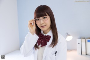 A woman in a school uniform sitting on a desk.