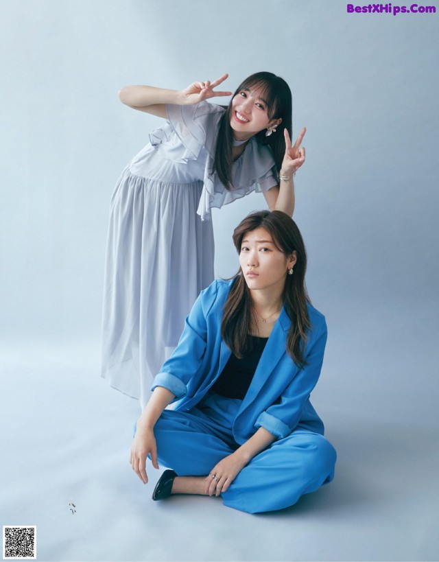 A woman in a blue suit sitting next to another woman.