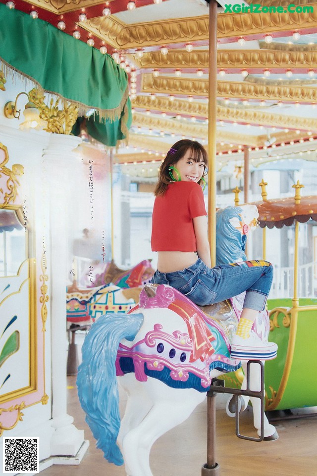 A woman sitting on top of a carousel horse.